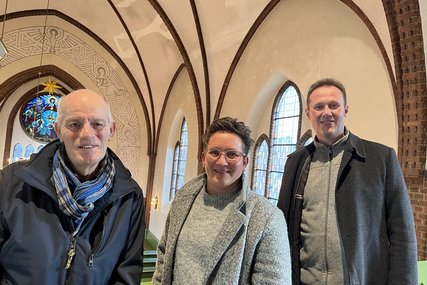 Drei Menschen in der Kirche blicken den Fotografen an. - Copyright: Annkathrin Bornholdt